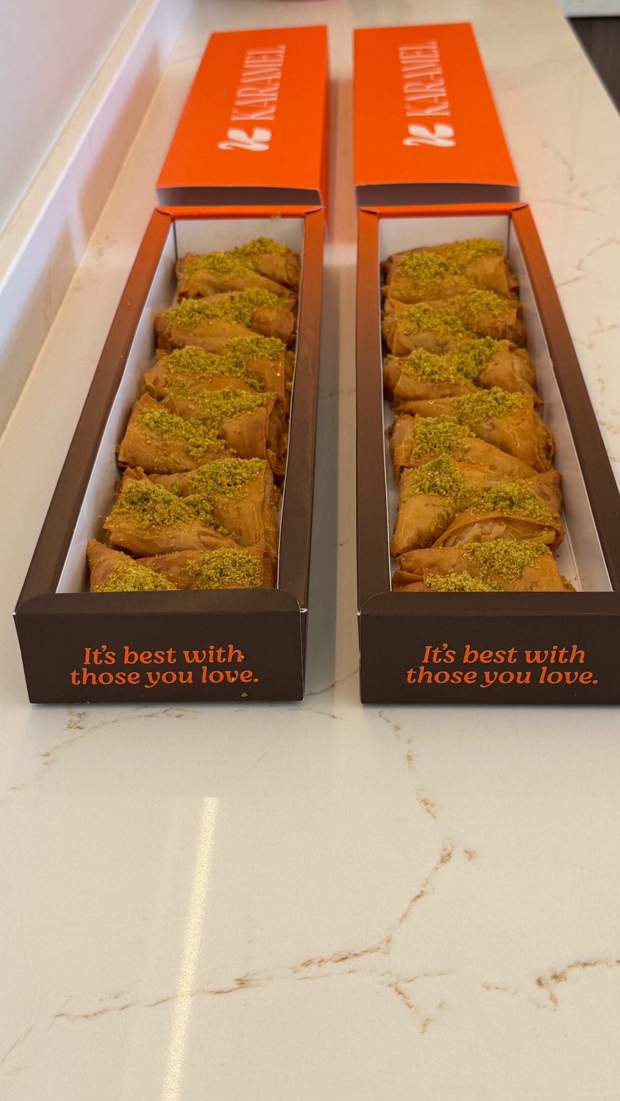 Two boxes of Karamel pistachio-topped pastries