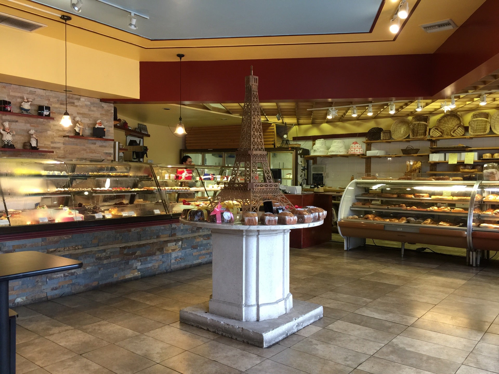 Le Bon Patissier bakery interior with Eiffel Tower wall art and pastry display cases